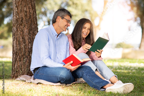 Literary Fans. Happy Middle Aged Man And Woman Reading Books In Park