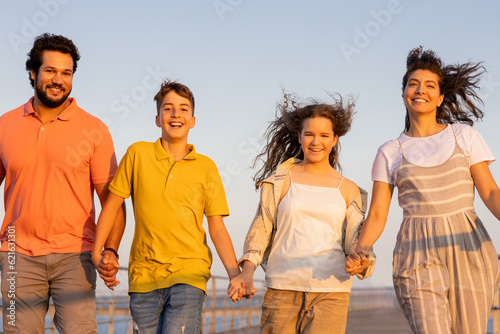 Smiling european millennial parents and teen kids holding hands, enjoy vacation, active lifestyle #621631301