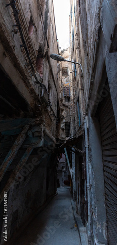 Very narrow alley with high residential buildings built close together, the Jewish mellah district in downtown Fes