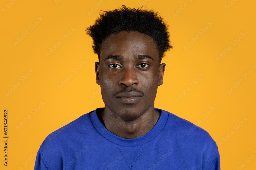 Handsome millennial black guy in casual posing on yellow background Handsome millennial black guy in casual posing on yellow background