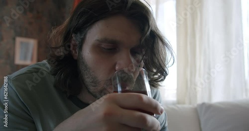 Man with alcohol addiction drinking whiskey, get his hangover alcohol dose. Alcoholic hand tremor, hand shakes alcohol withdrawal syndrome. Heavy drinker man with alcohol problems.