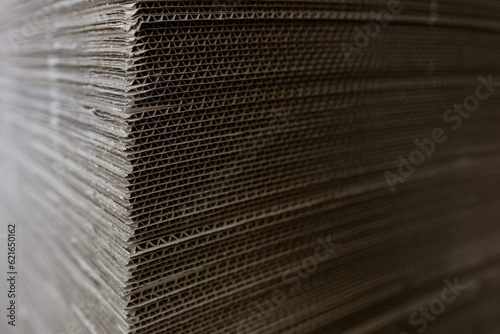 A cardboard sheets in stack. Perforated sheets of corrugated cardboard are stacked on pallets. Packaging of finished products in industrial production.
