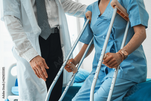 Photographie Doctor takes care of patient in crutch at hospital