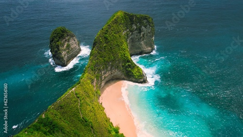 Pristine sandy Kelingking Beach on Nusa Penida island Bali. Turquoise ocean water by green limestone cliffs. Famous natural landmark.