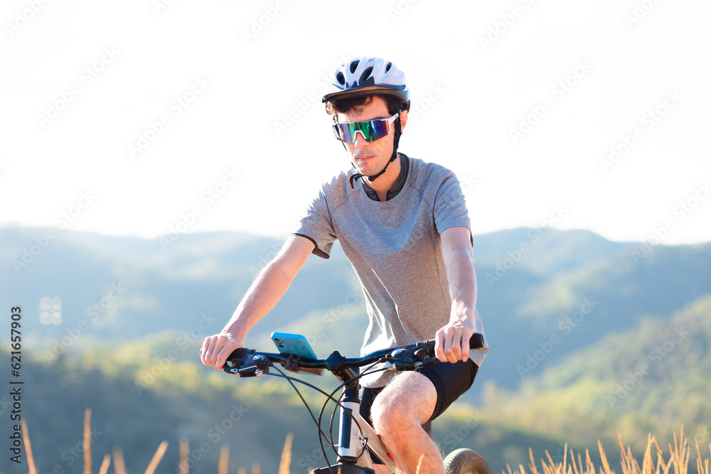 Man riding on mountain bike down a trail with mountains in the background. Man riding on mountain bike down a trail with mountains in the background.
