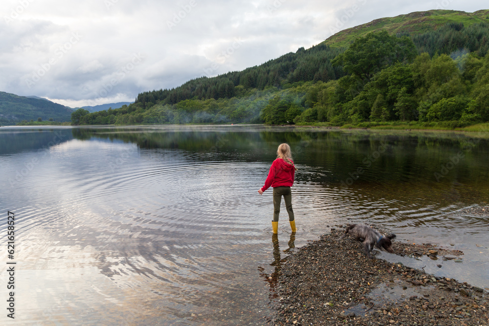 Child playing on a Loch in the Scottish Highlands, on a summers day