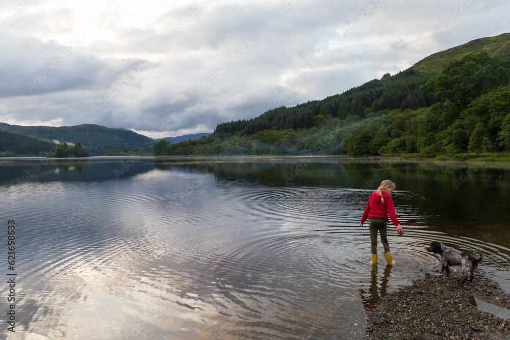 Child playing on a Loch in the Scottish Highlands, on a summers day
