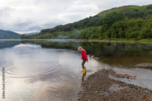 Child playing on a Loch in the Scottish Highlands, on a summers day