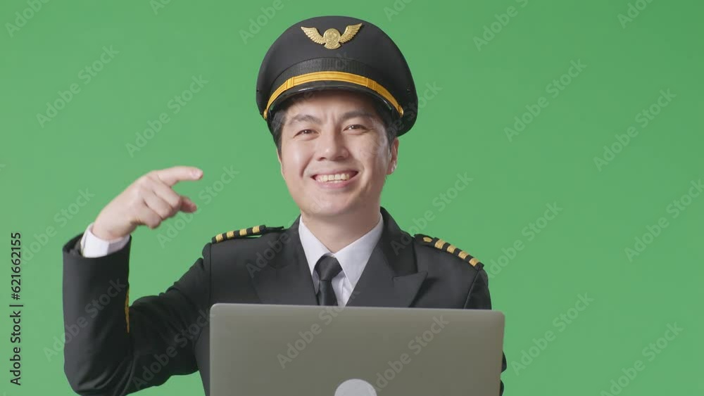 Close Up Of Asian Man Pilot Smiling And Pointing To A Laptop In His Hand While Standing In The Green Screen Background Studio
Close Up Of Asian Man Pilot Smiling And Pointing To A Laptop In His Hand While Standing In The Green Screen Background Studio