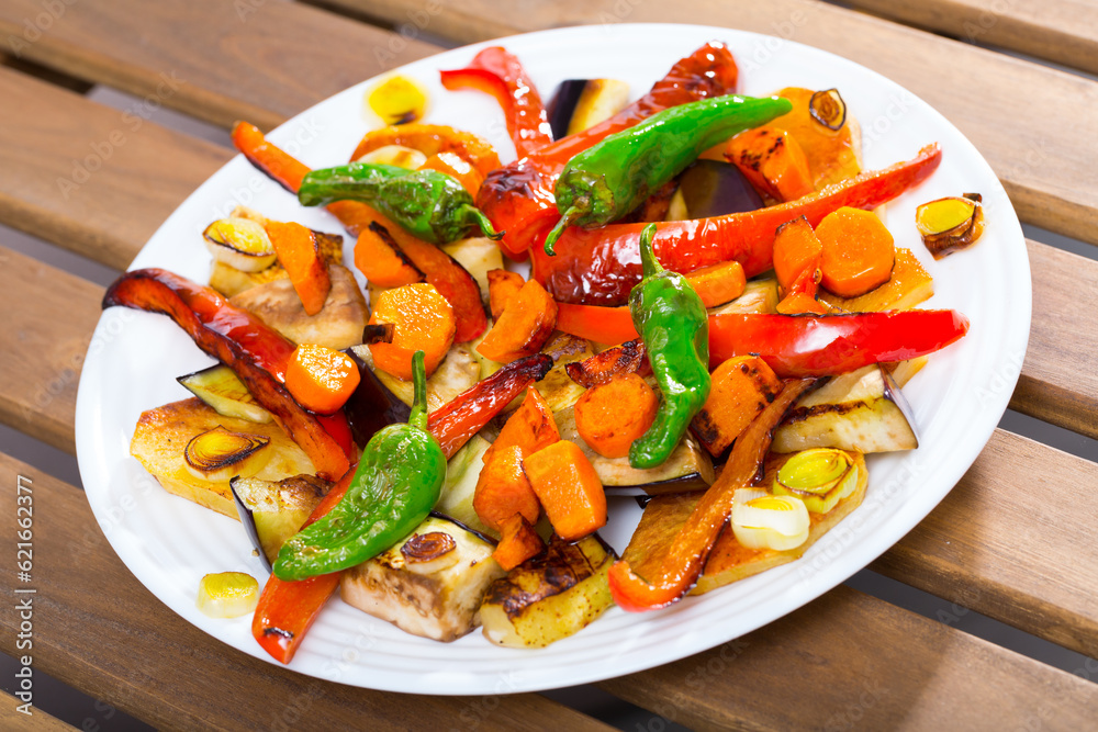 Plate with sliced vegetables baked in the oven - carrot, pepper, eggplant