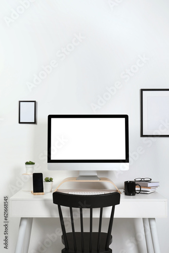 Cozy workspace with computer, smartphone and stationery on wooden desk at home © New Africa