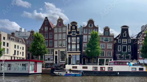 Traditional old narrow houses boats and canals Amsterdam, Netherlands, Europe, July 5 2023 . High quality 4k footage