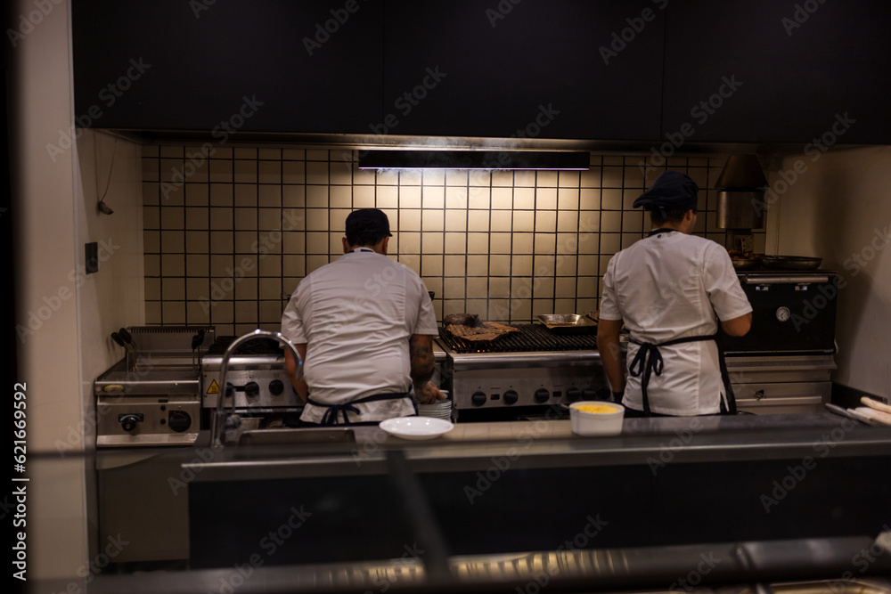 Two cooks at work in the kitchen Two cooks at work in the kitchen