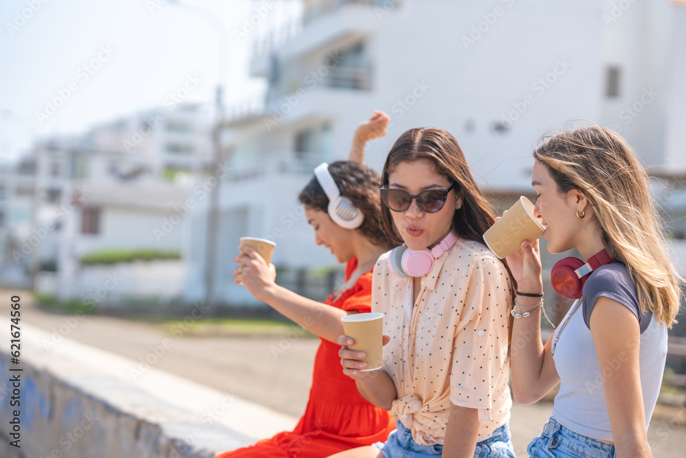 Three friends having fun sitting on the boardwalk