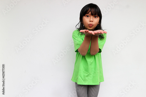 A cute confident girl raised her hands to blow a kiss or air kiss