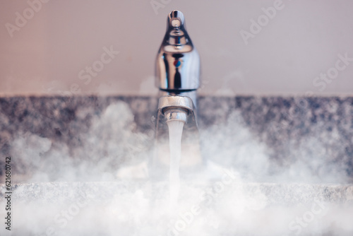 bathroom sink with chrome faucet and steam rising