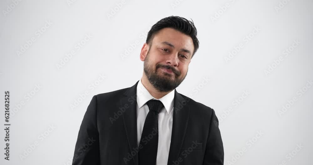The gestures and facial expressions of a middle-aged businessman in close-up shots in a studio, as he looks at the camera and displays an expression of weariness