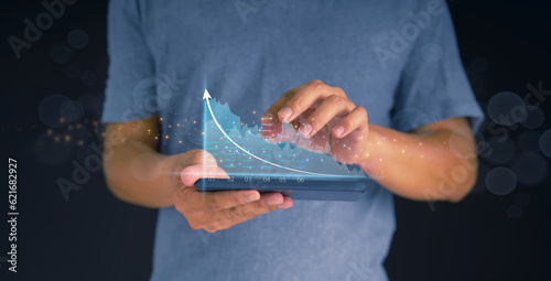 Investors use smartphones for planning and strategy, stock market, and business growth. progress or success businessman or merchant concept showing growing virtual hologram stocks invest in trading
