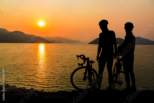 A young couple watching the sunset by the sea