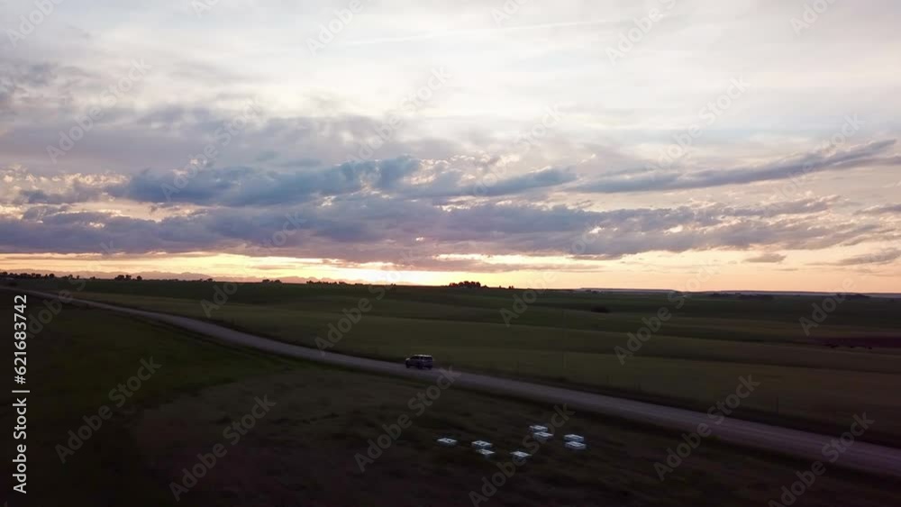 Aerial Shot Of Car Moving On Country Road Against Sunset Sky, Drone Flying Over Scenic Landscape - Billings, Montana Aerial Shot Of Car Moving On Country Road Against Sunset Sky, Drone Flying Over Scenic Landscape - Billings, Montana
