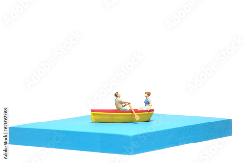 Creative miniature people toy figure photography. Sticky notes installation. A couple dating on a boat at river lake sea. Isolated on white background
