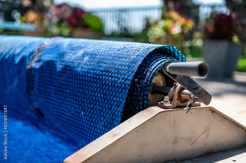Manual real for a retractable floating pool cover to keep out leaves