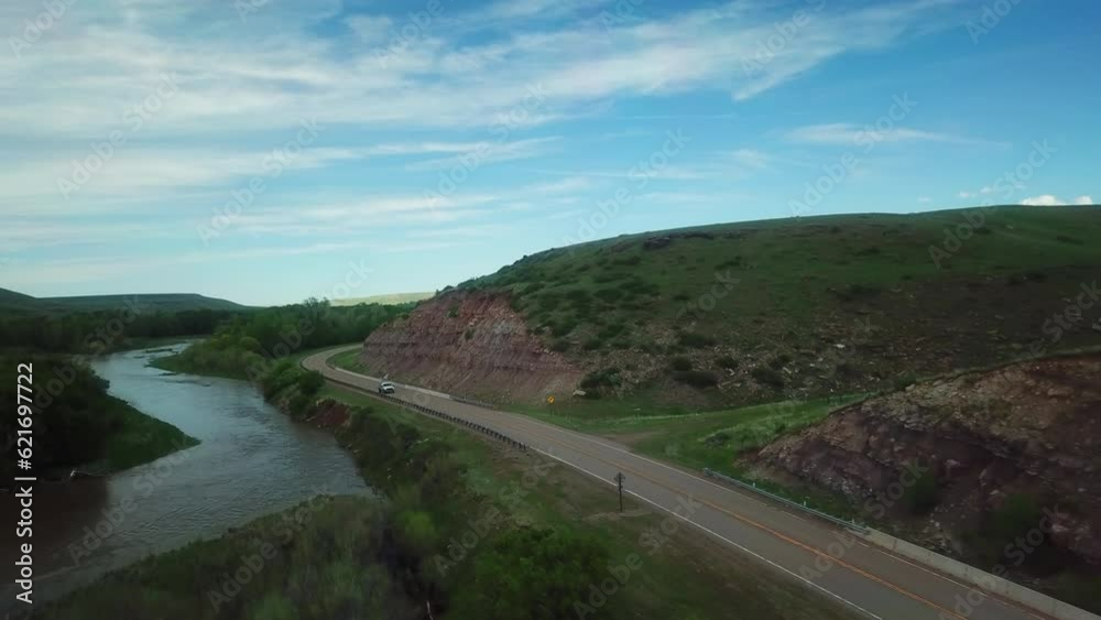Aerial Shot Of Vehicle On Road Passing By Mountain Against Sky, Drone Flying Over Landscape - Billings, Montana Aerial Shot Of Vehicle On Road Passing By Mountain Against Sky, Drone Flying Over Landscape - Billings, Montana