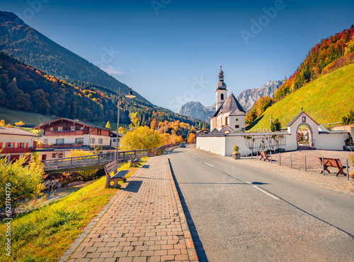 Beautiful autumn scenery. Superb morning scene of Parish Church of St. Sebastian. Colorful autumn view of Bavarian Alps, Ramsau village with asphalt road, Germany, Europe.