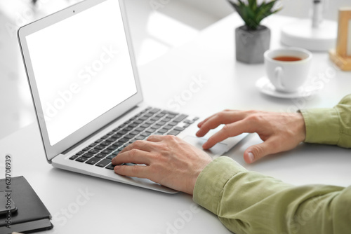 Man with laptop working in office, closeup
