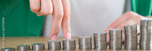 Woman fingers going up on bar chart collected of silver coins photo