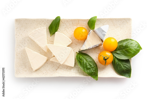 Plate with triangles of tasty processed cheese, cherry tomatoes and basil leaves on white background