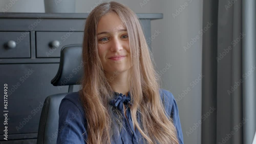 Woman looking up from laptop and making eye contact, in Slow Motion. Kind welcoming smile from a young female worker in the office. Woman looking up from laptop and making eye contact, in Slow Motion. Kind welcoming smile from a young female worker in the office.