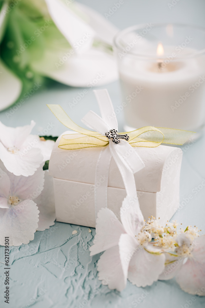 Confirmation or First holy communion concept - small present with candle and flowers Confirmation or First holy communion concept - small present with candle and flowers