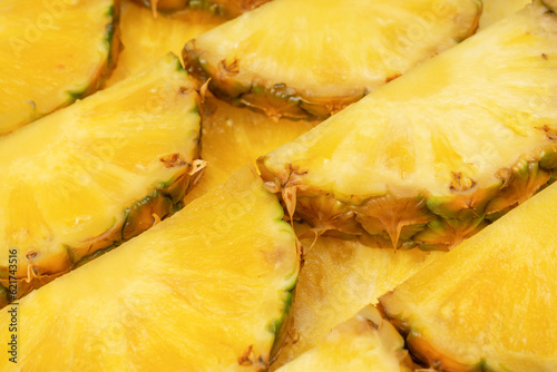 Pineapple juicy yellow slices as a background.