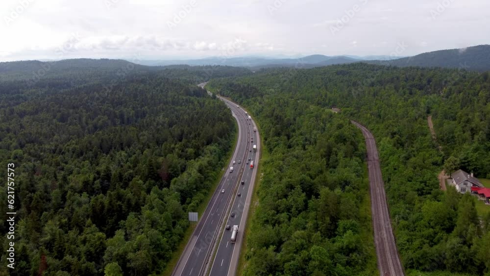 European 2-lane highway with nice traffic flow and railroad and rails right beside it and green belt surrounding the national road European 2-lane highway with nice traffic flow and railroad and rails right beside it and green belt surrounding the national road