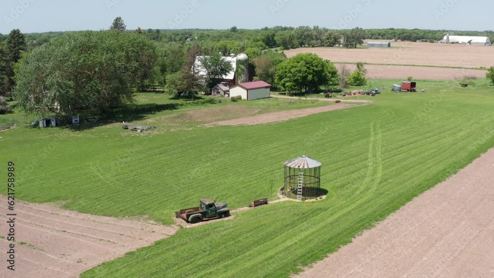 Close-up descending aerial shot of an empty corn silo and old farm truck in the rural fields of Minnesota. 4K Close-up descending aerial shot of an empty corn silo and old farm truck in the rural fields of Minnesota. 4K