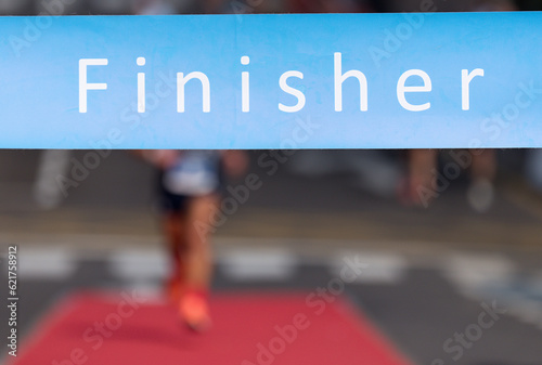 Man running towards the finish line, male runner win the race outdoor in the city. Passes finish line as a winner