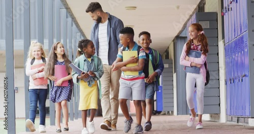 Wallpaper Mural Diverse male teacher and happy schoolchildren walking at school Torontodigital.ca