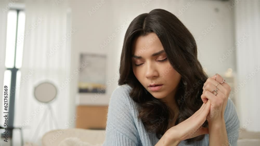 Close up portrait of upset woman siting on sofa alone at modern home troubled with negative thoughts slow motion. Beautiful face of sad thoughtful young Latin American single woman thinking of problem Close up portrait of upset woman siting on sofa alone at modern home troubled with negative thoughts slow motion. Beautiful face of sad thoughtful young Latin American single woman thinking of problem