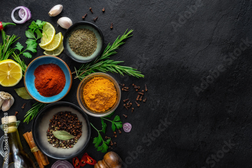 Food cooking ingredients background with various spices on dark stone table with copy space top view