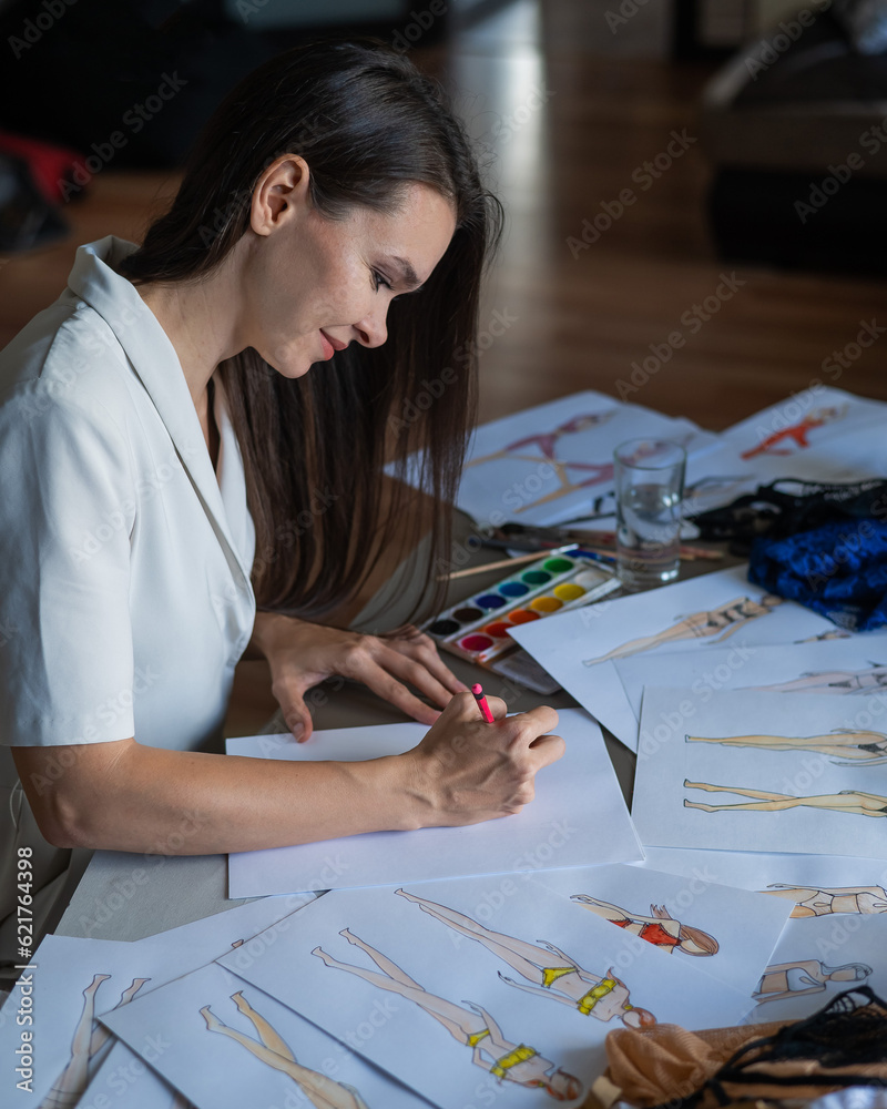 Woman drawing sketches of swimwear and underwear in watercolor. 