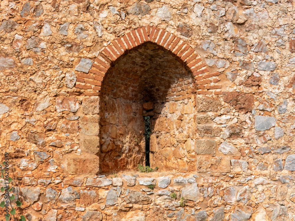 An ancient stone wall of Alanya fortress with an arched window