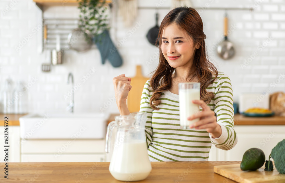 Portrait of beauty healthy asian woman smiling and having protein breakfast drinking and hold glasses of milk of fresh milk, nutrition,calcium and vitamin,dairy product in kitchen at home.Diet concept Portrait of beauty healthy asian woman smiling and having protein breakfast drinking and hold glasses of milk of fresh milk, nutrition,calcium and vitamin,dairy product in kitchen at home.Diet concept