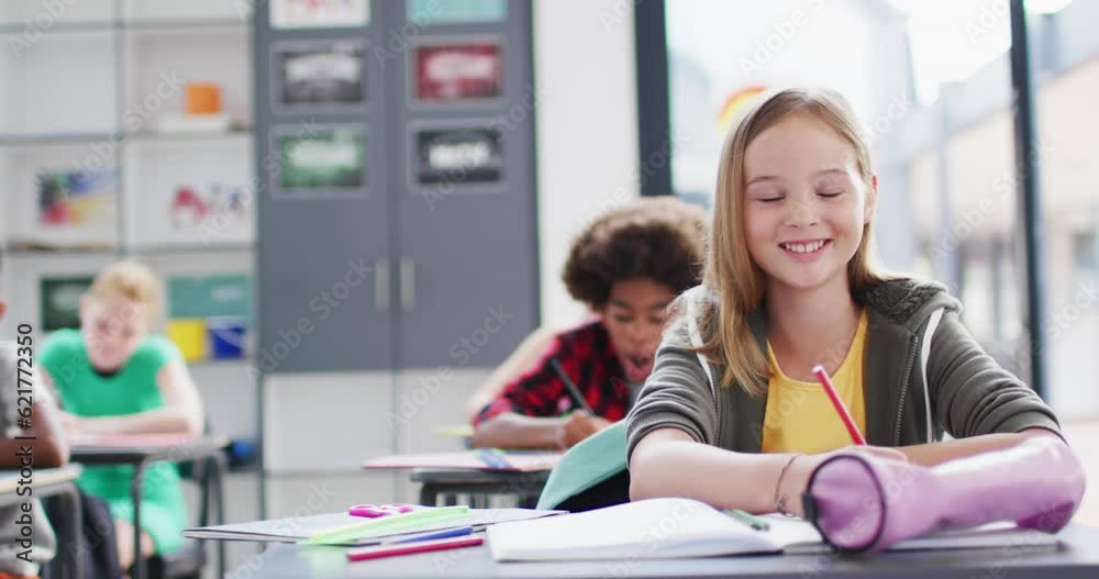 Portrait of happy diverse schoolchildren at desks in school classroom Portrait of happy diverse schoolchildren at desks in school classroom