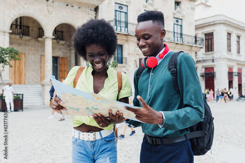 Photography Young afro american couple tourist looking a map while on vacation during summer