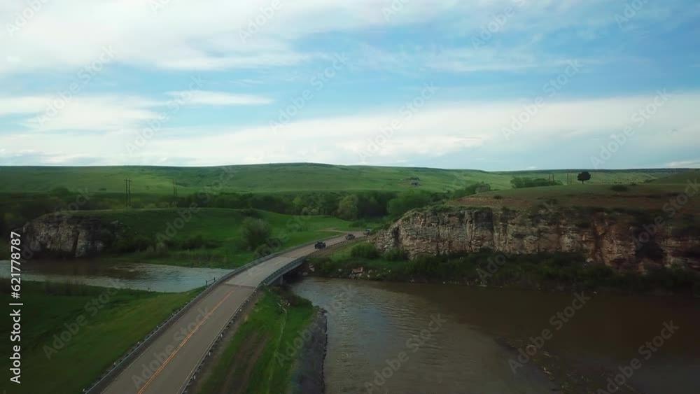 Aerial Shot Of Vehicles Moving On Country Road Over River, Drone Flying Forward Over Landscape - Billings, Montana Aerial Shot Of Vehicles Moving On Country Road Over River, Drone Flying Forward Over Landscape - Billings, Montana