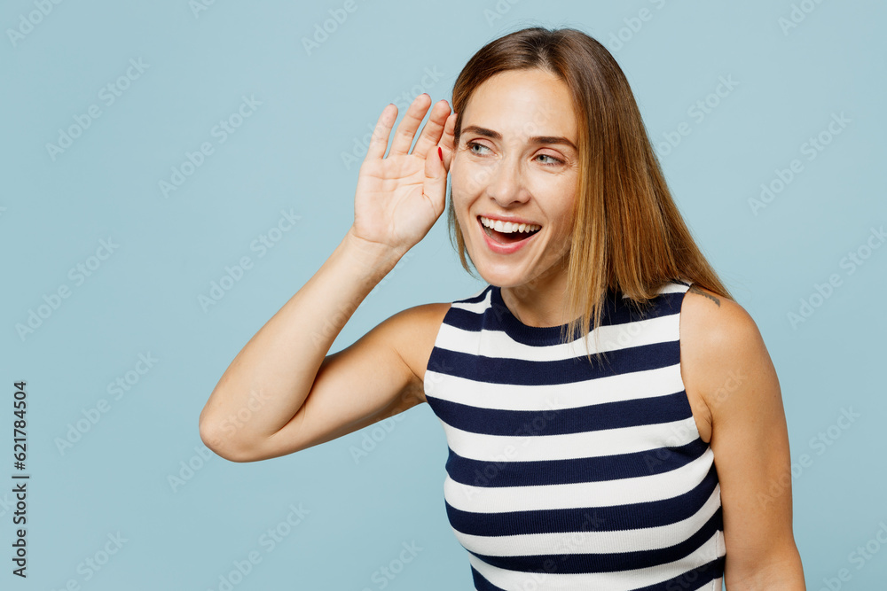 Young curious nosy blonde woman in striped tank shirt casual clothes try to hear you overhear listening intently isolated on plain pastel light blue cyan background studio portrait Lifestyle concept Young curious nosy blonde woman in striped tank shirt casual clothes try to hear you overhear listening intently isolated on plain pastel light blue cyan background studio portrait Lifestyle concept