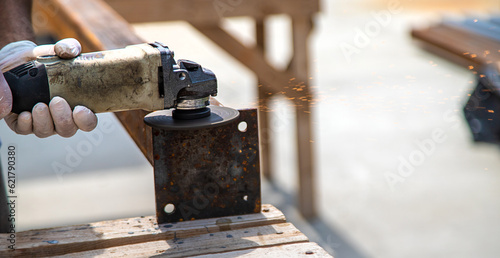 A man processes a metal pole. Selective focus.