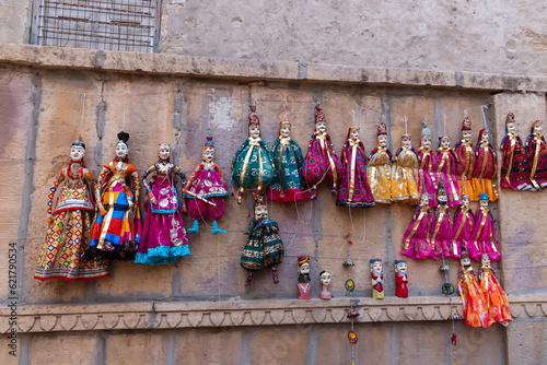 Jaisalmer, Rajasthan, India - 16 th October 2019 : Traditional Rajasthani Raja Rani dolls hanging from wall for sale near Patwon Ki Haveli. These are favourite for trourists travelling Jaisalmer. © mitrarudra
