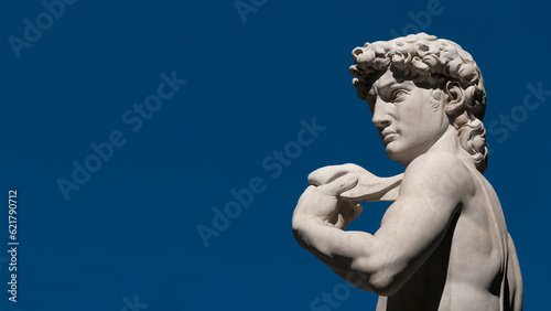 Michelangelo's David, a masterpiece of sculpture symbol of Italian Renaissance. Outdoor replica in Florence (with blue sky and copy space)